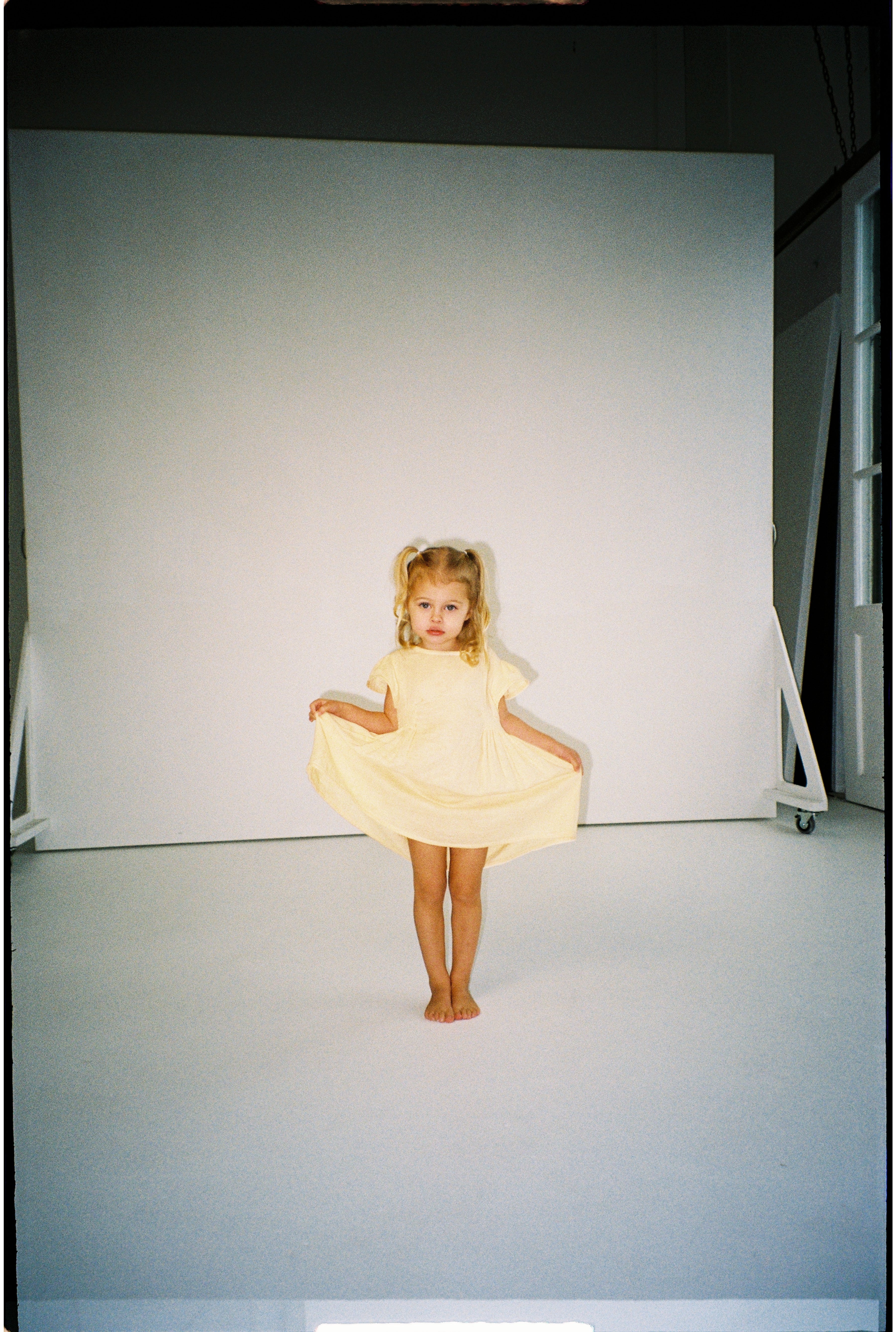 toddler girl wearing 100% cotton dress with shirring and flutter sleeves in butter yellow