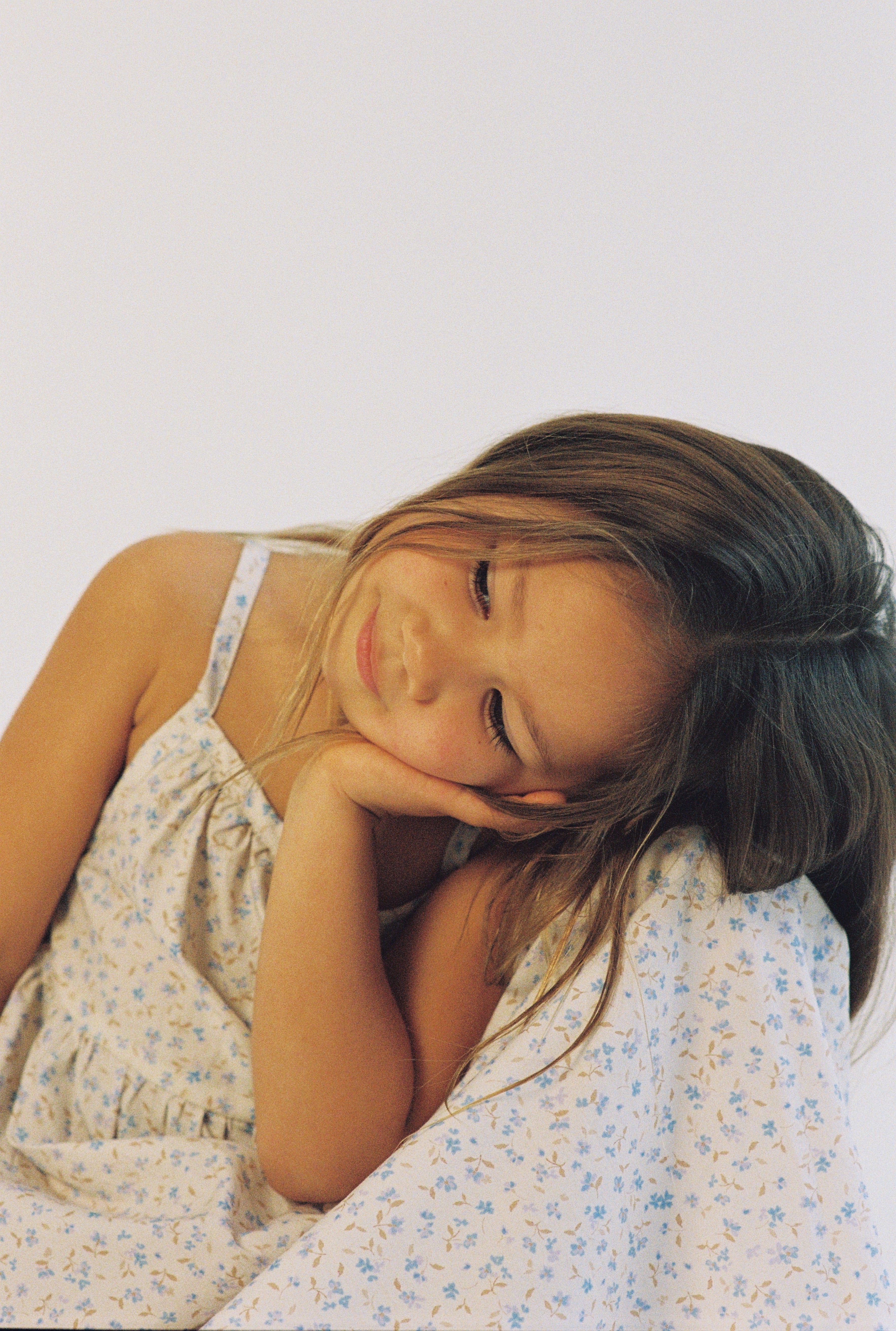 girl wearing 3/4 length floral printed dress made from 100% cotton poplin with thin straps and gathers at the chest and waist