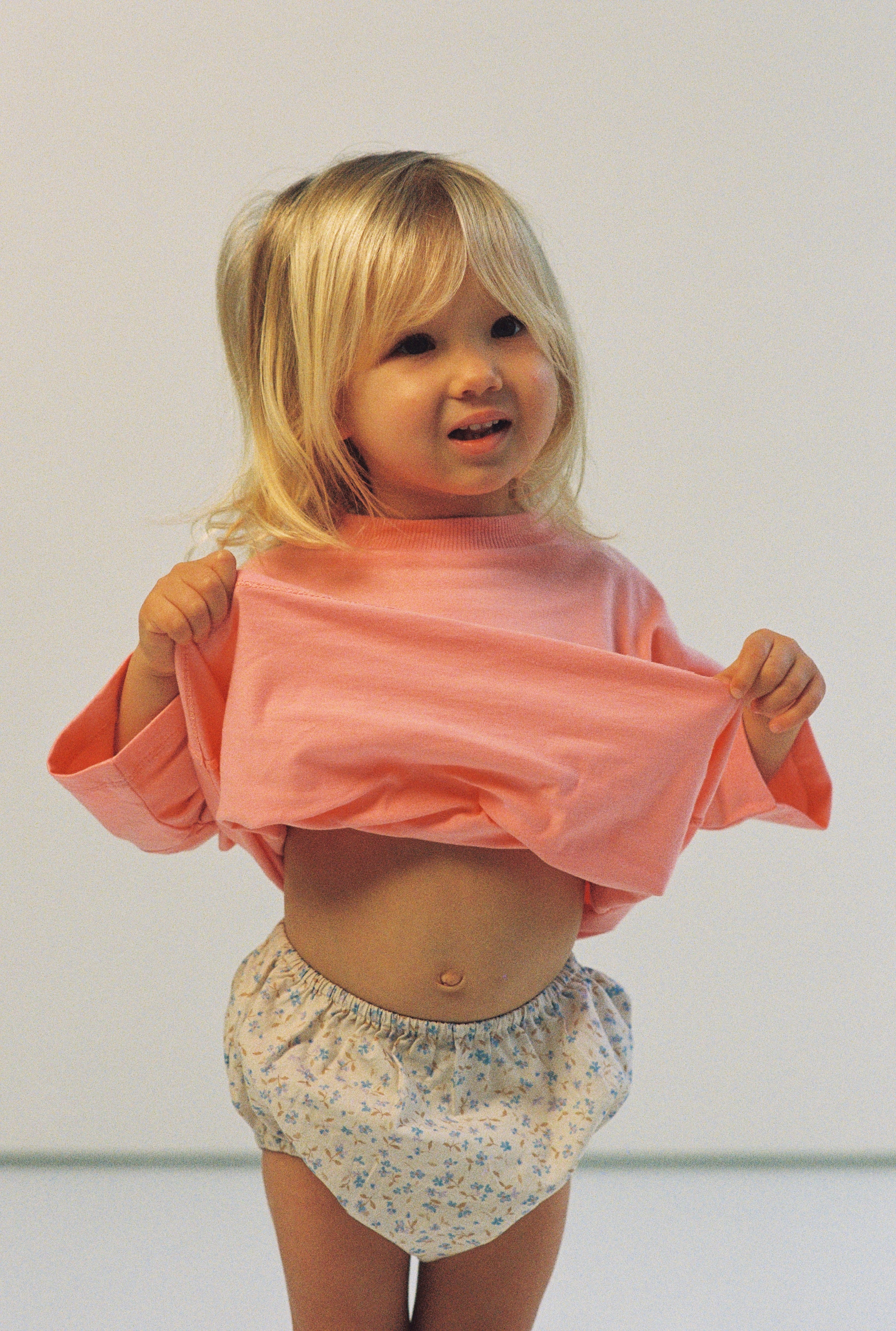 baby girl wears bloomers 100% cotton poplin in blue floral print with elasticated waist and legs with a pink 100% cotton t-shirt