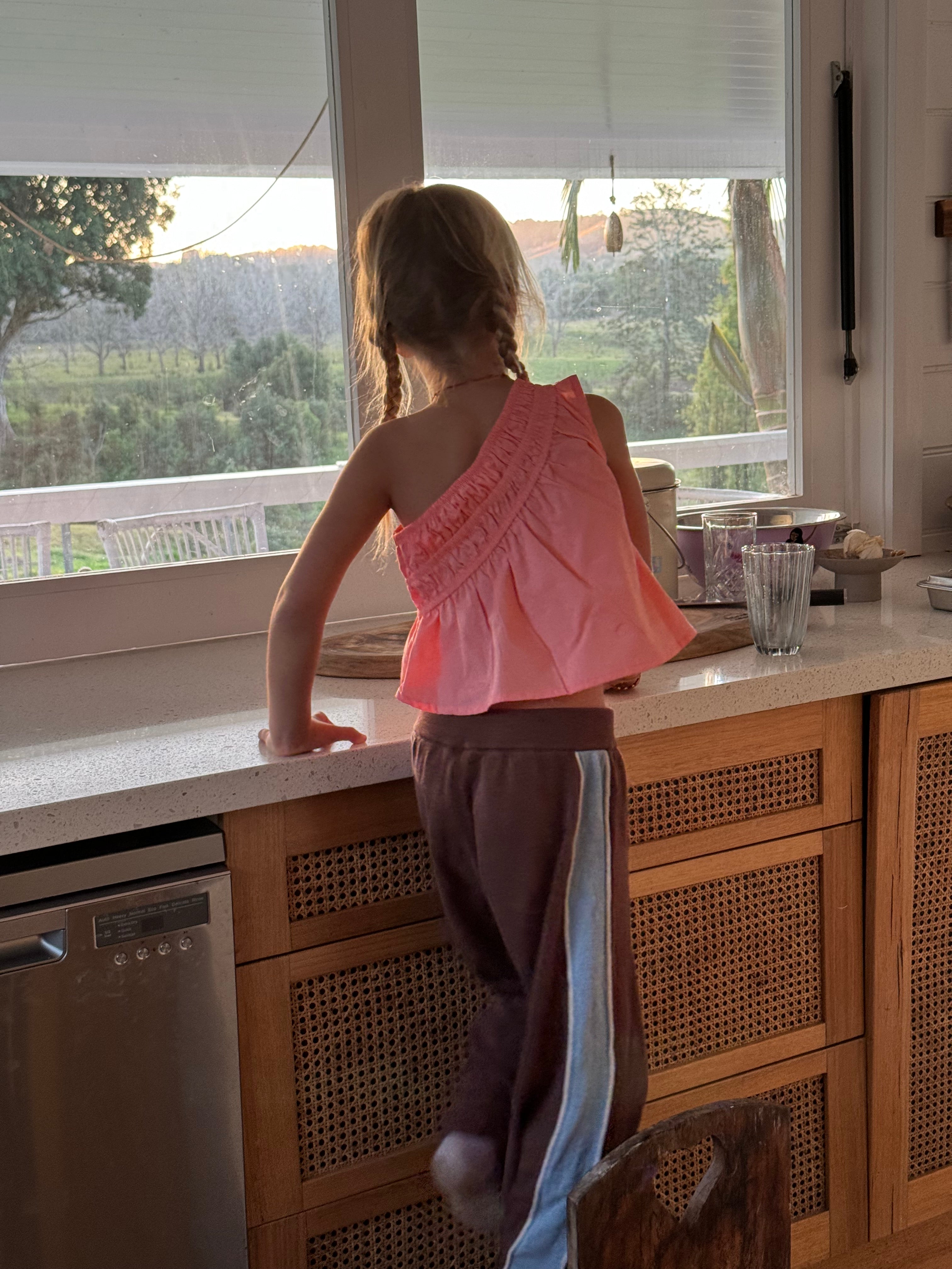 girl wearing linen cotton blend knitted pants in chocolate with blue panel and white piping by illoura the label