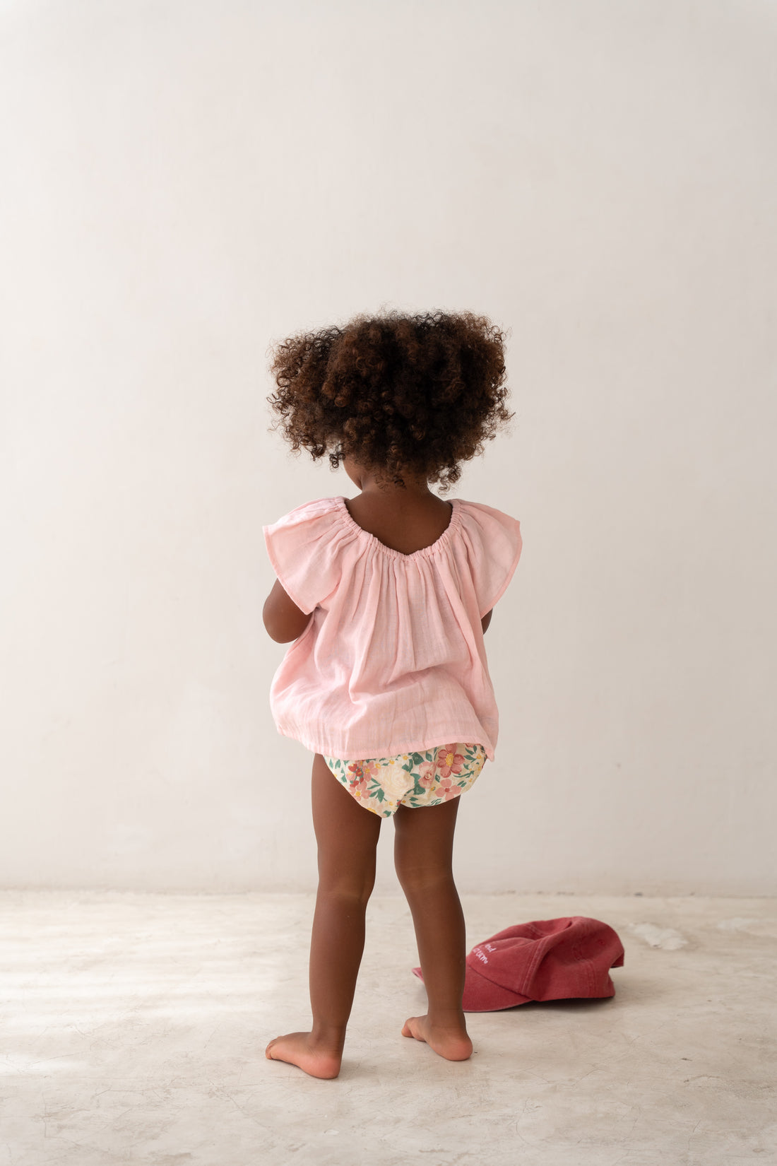 toddler girl wearing pink cotton blouse and floral bloomers by Illoura the label
