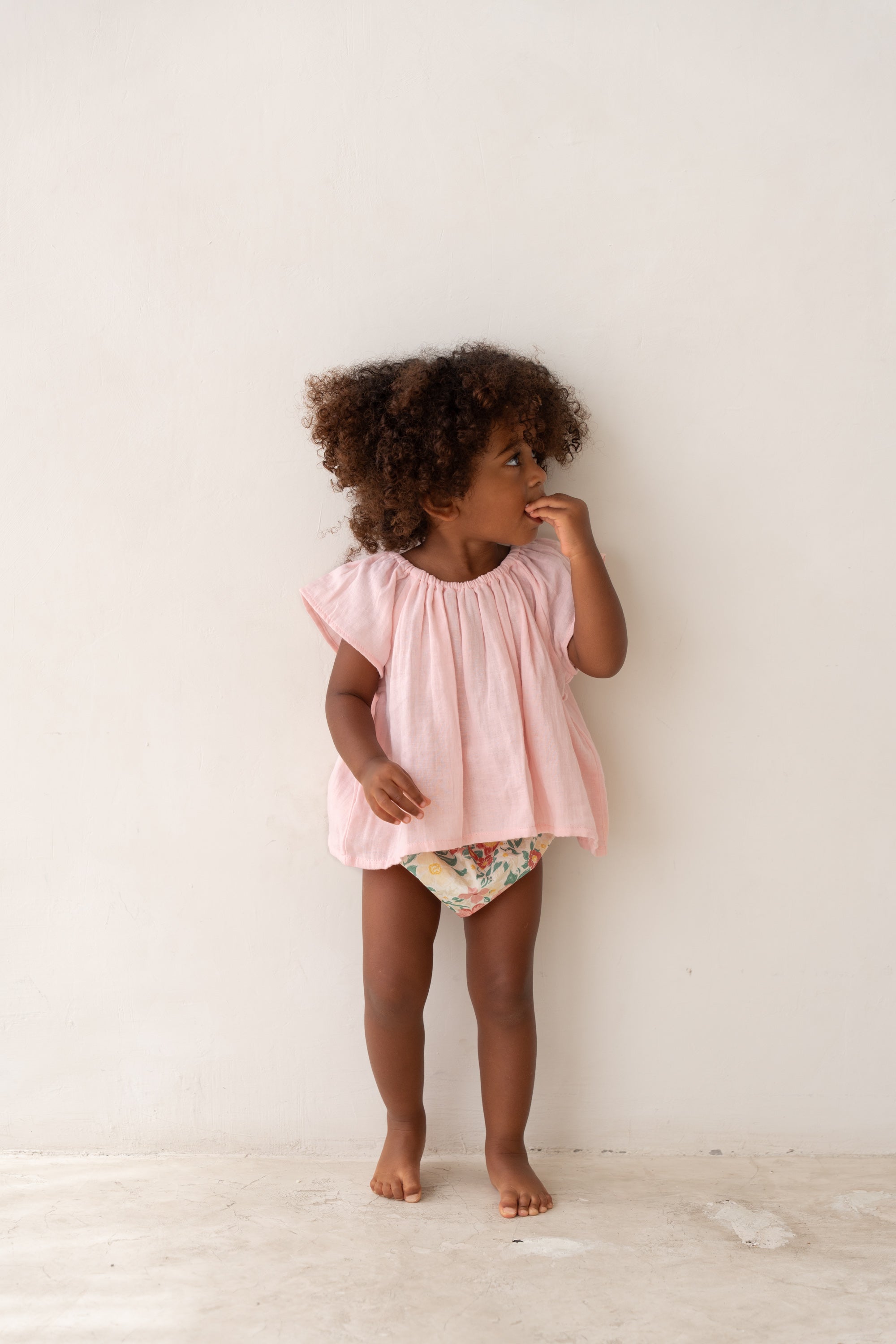 toddler girl wearing pink cotton blouse and floral bloomers by Illoura the label