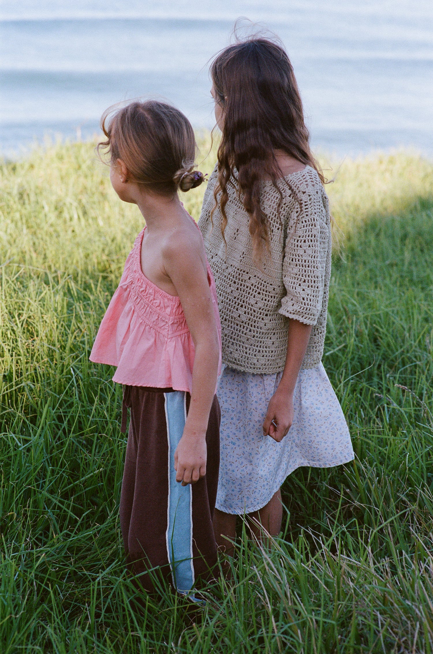 girl wears 100% cotton t-shirt style crochet top in moss green colour featuring floral filet design and 100% cotton poplin skirt in blue floral print