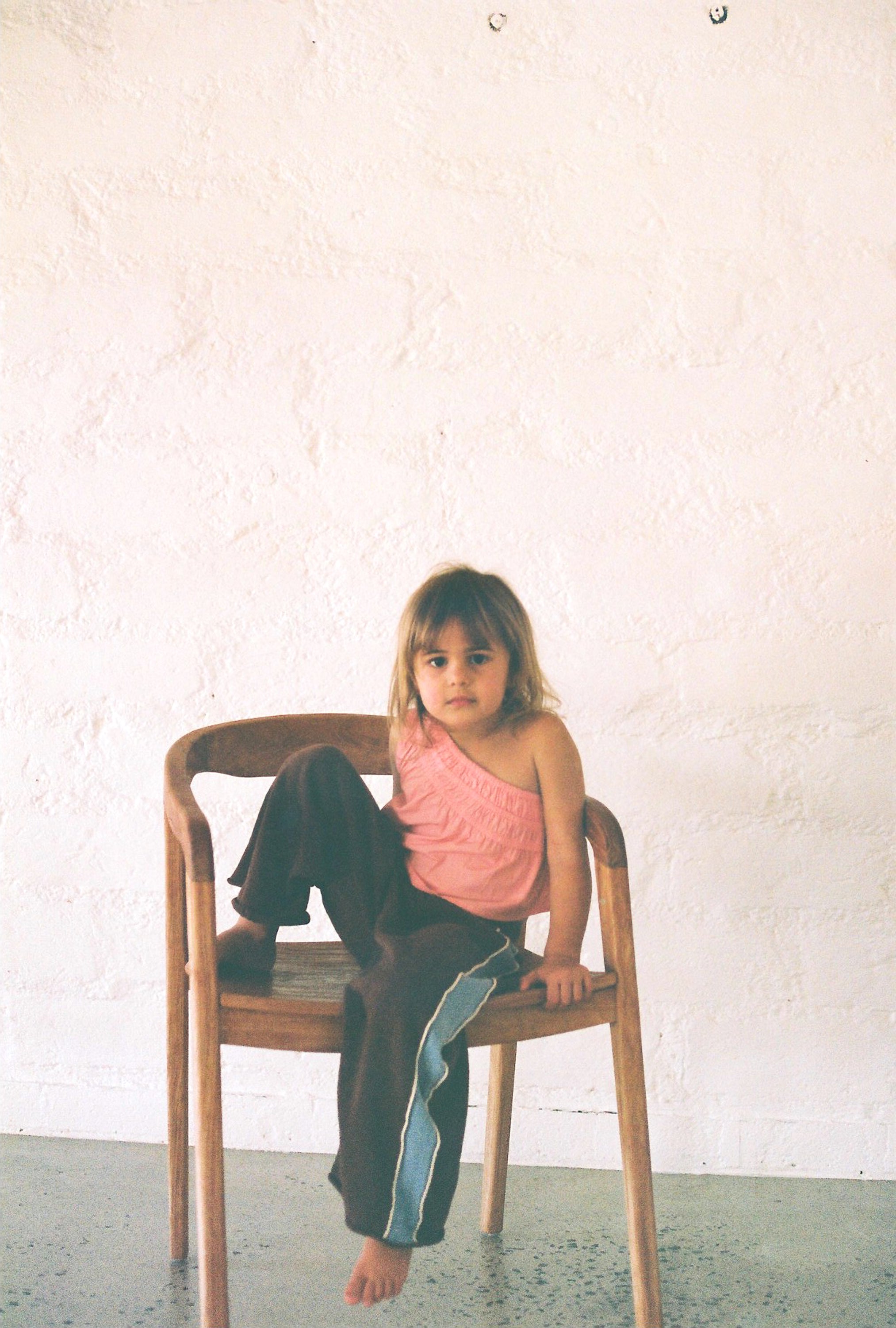girl wears linen/cotton blend knit pants in chocolate brown colour with blue panels up the side and white piping and elasticated waist band
