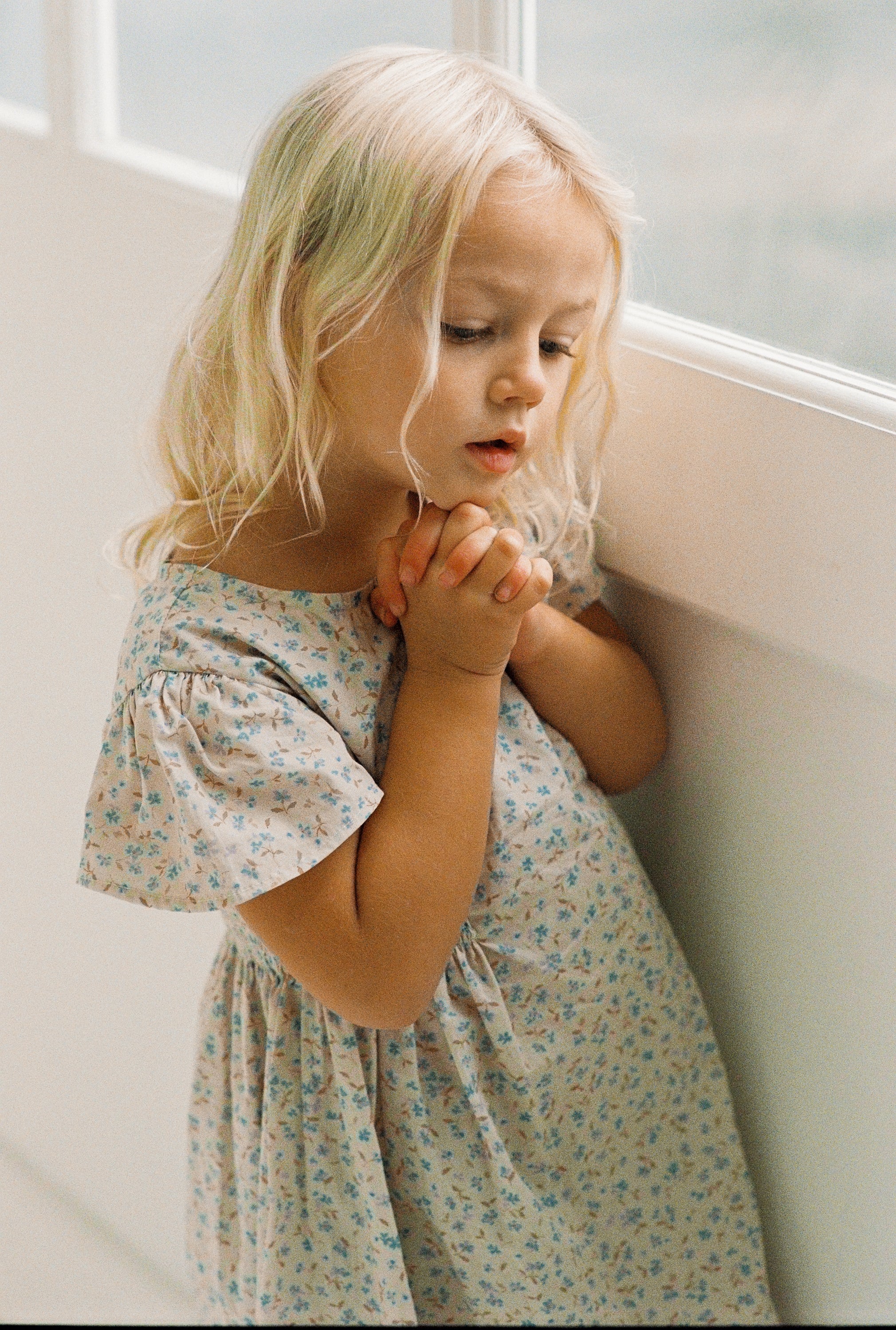 girl wearing floral print mini dress in 100% cotton poplin with shirring and flutter sleeves