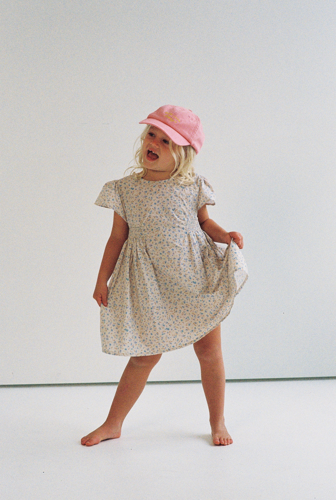 girl wearing floral print mini dress in 100% cotton poplin with shirring and flutter sleeves