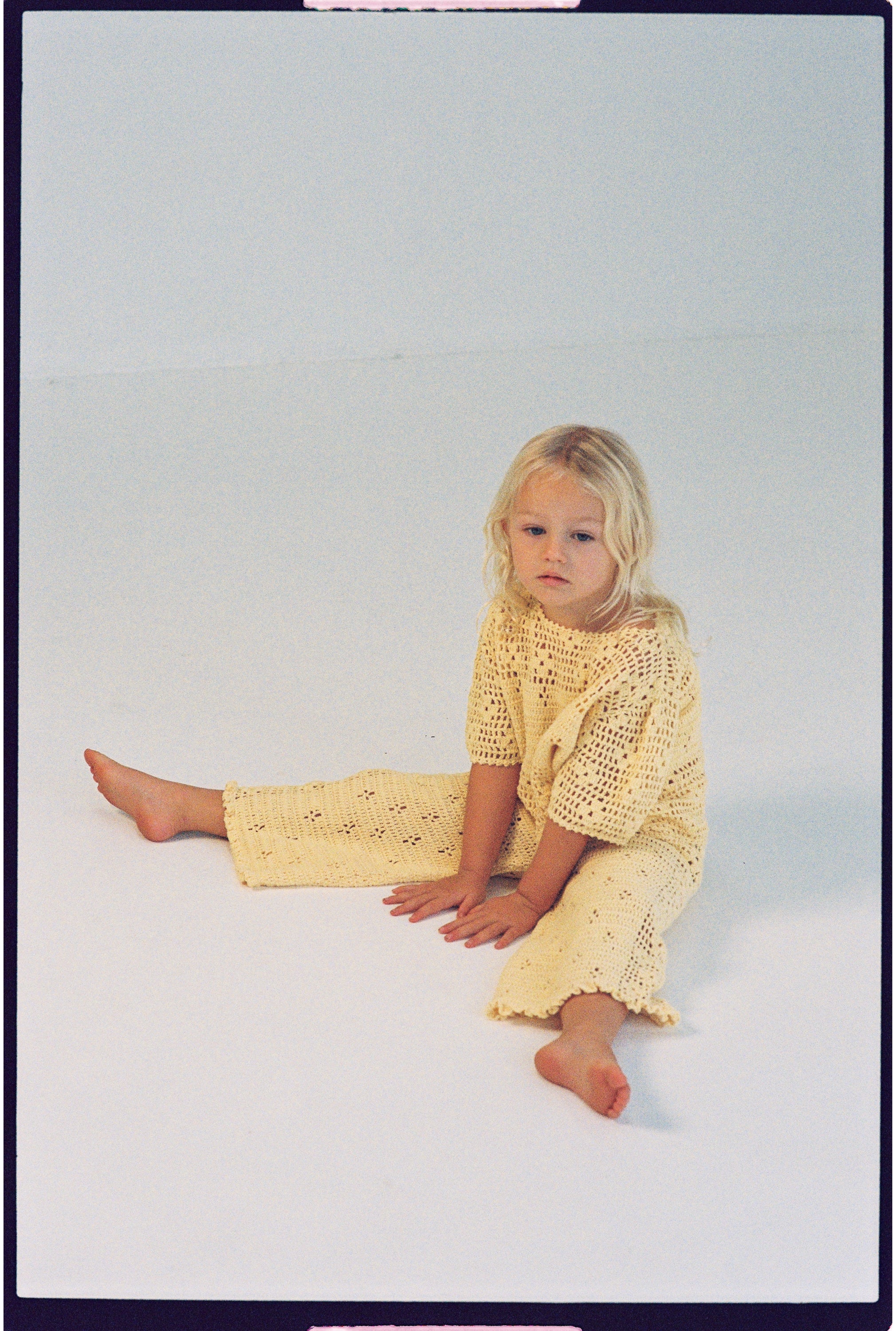 girl wearing handmade cotton crochet top and pants in butter yellow by Illoura the label