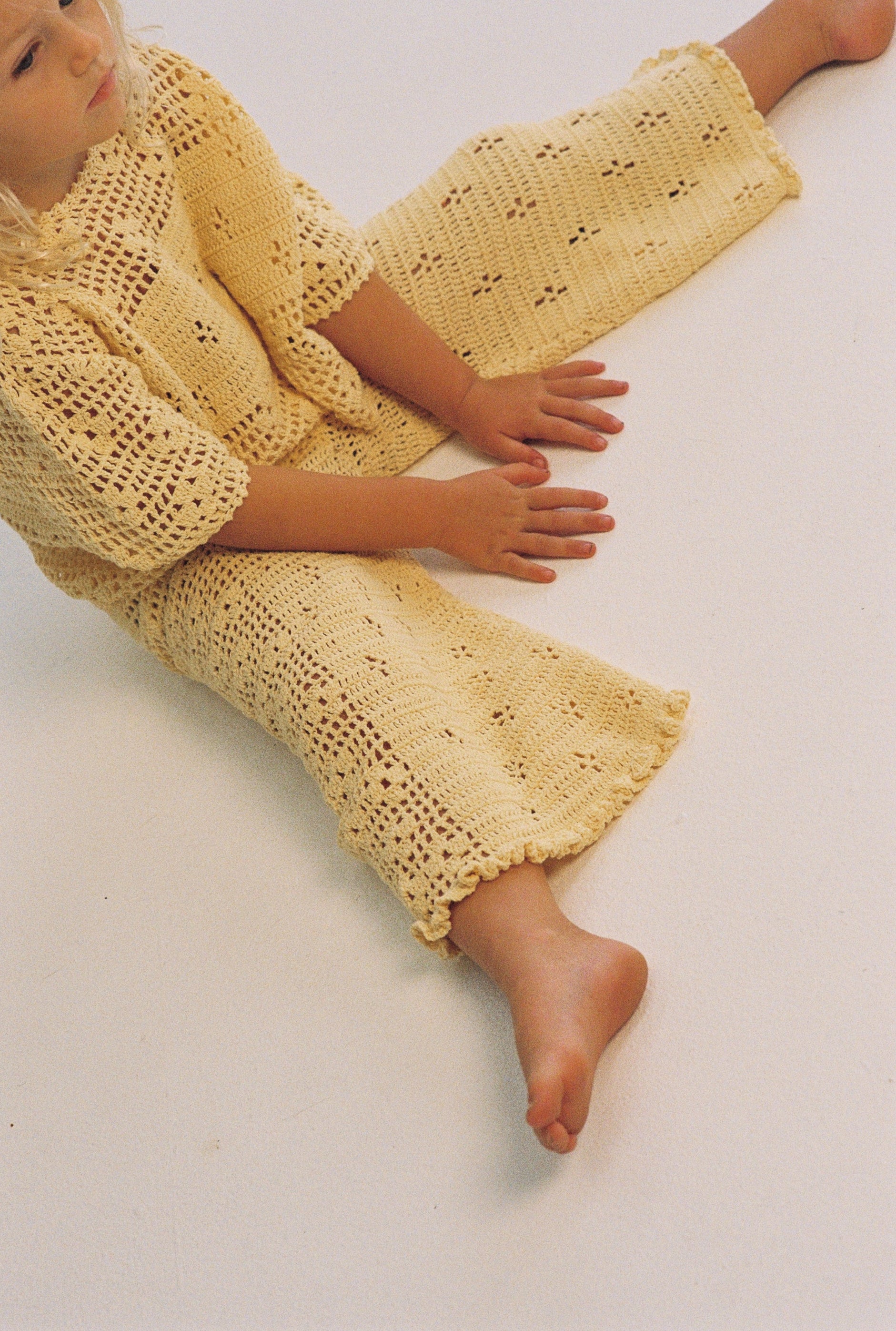 girl wearing handmade cotton crochet top and pants in butter yellow by Illoura the label