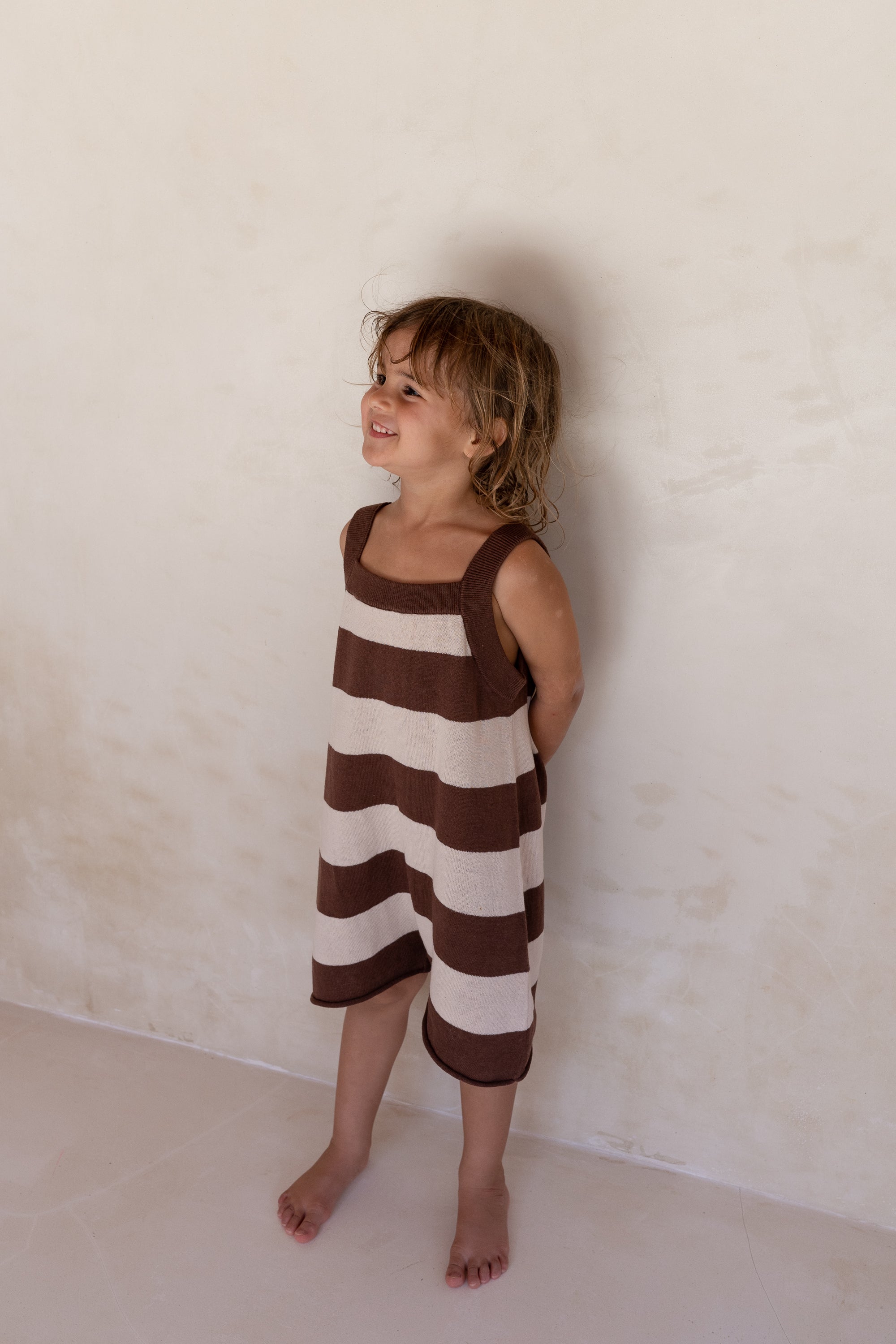 girl wearing cotton linen blend knitted romper in choc stripe by Illoura the label