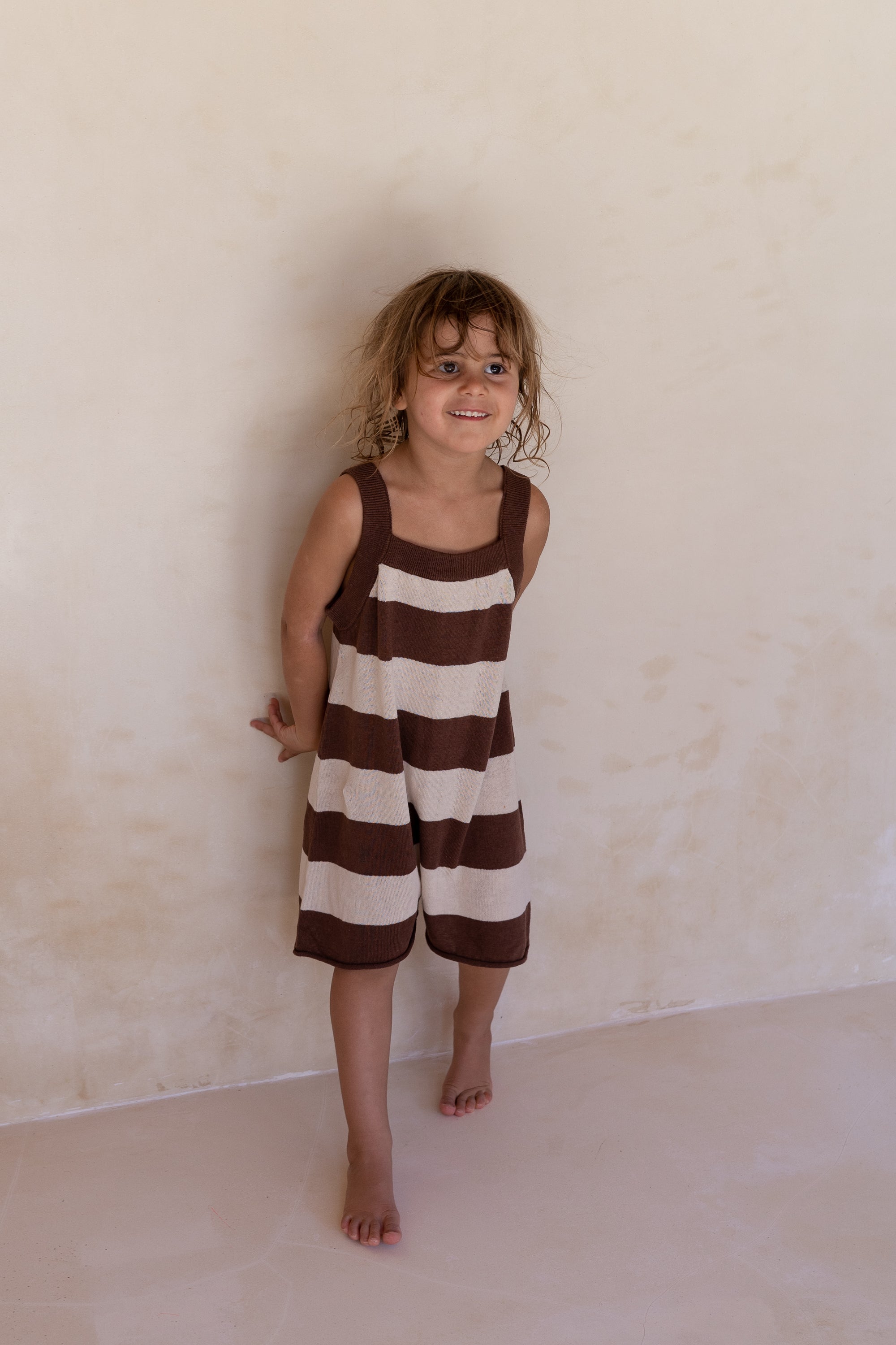 girl wearing cotton linen blend knitted romper in choc stripe by Illoura the label
