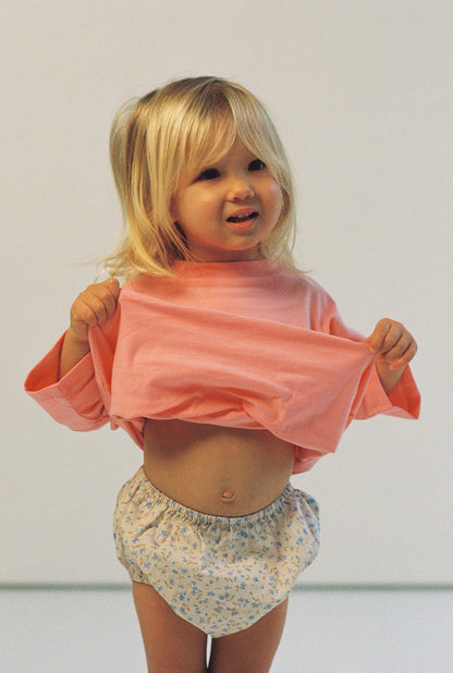 baby girl wears bloomers 100% cotton poplin in blue floral print with elasticated waist and legs with a pink 100% cotton t-shirt