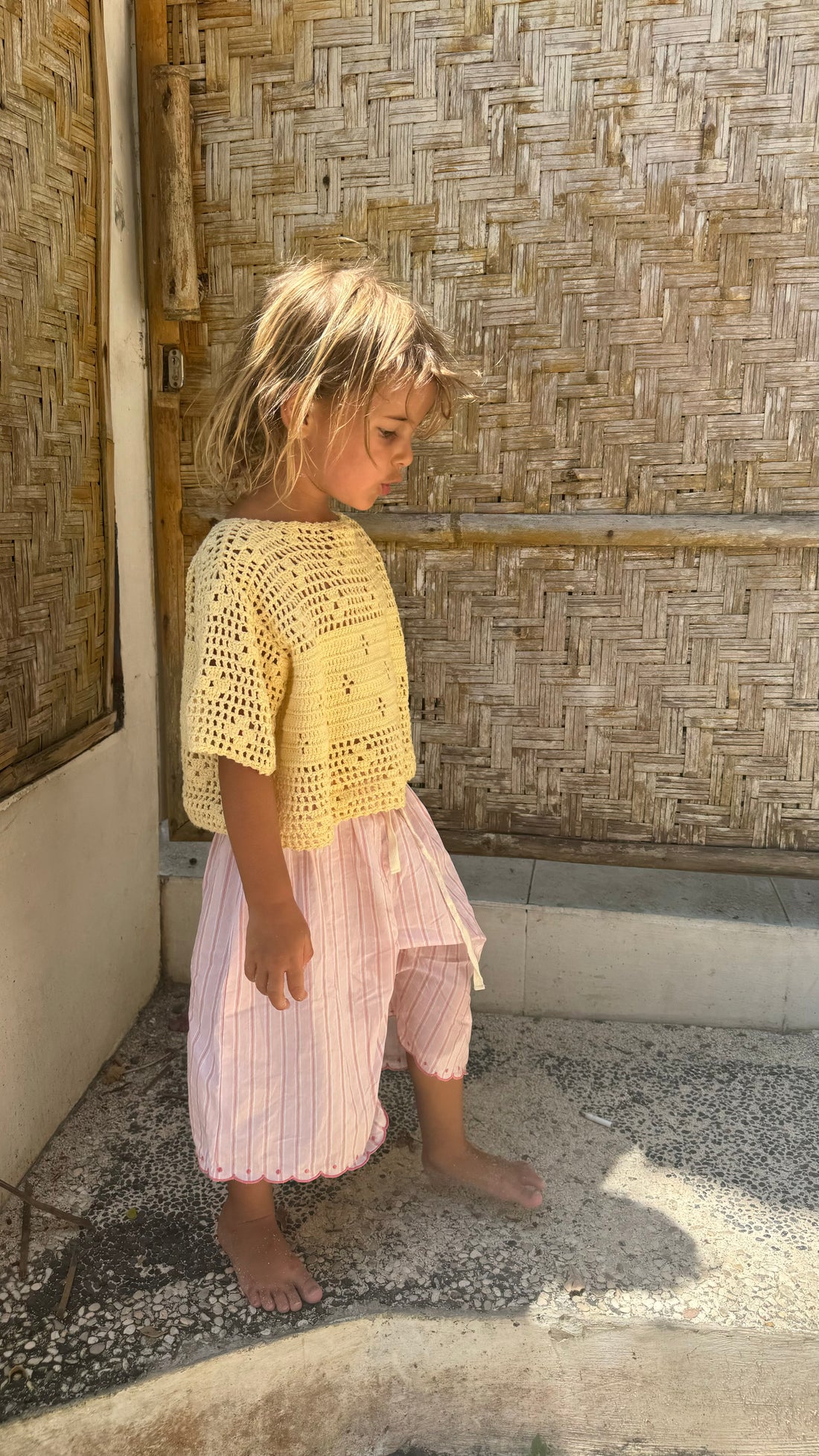 girl wearing handmade cotton crochet top in butter and cotton pink stripe wide leg pants by illoura the label