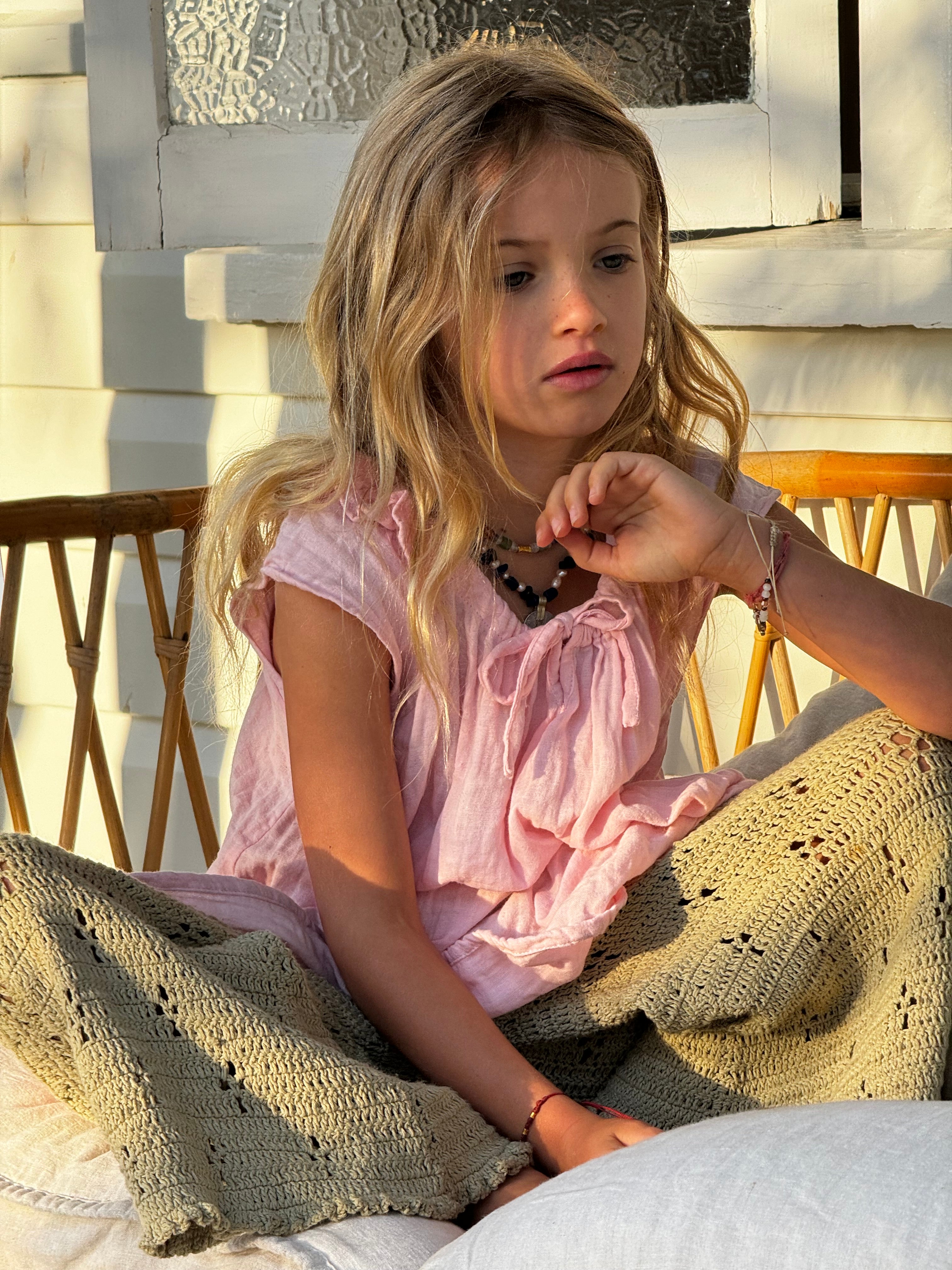 girl wearing pink cotton dress and green cotton crochet pants by Illoura the label