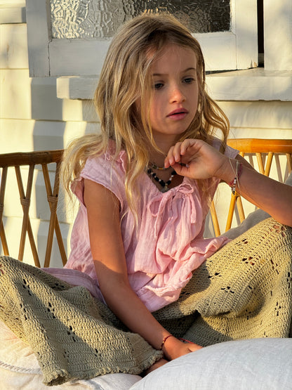 girl wearing pink cotton dress and green cotton crochet pants by Illoura the label