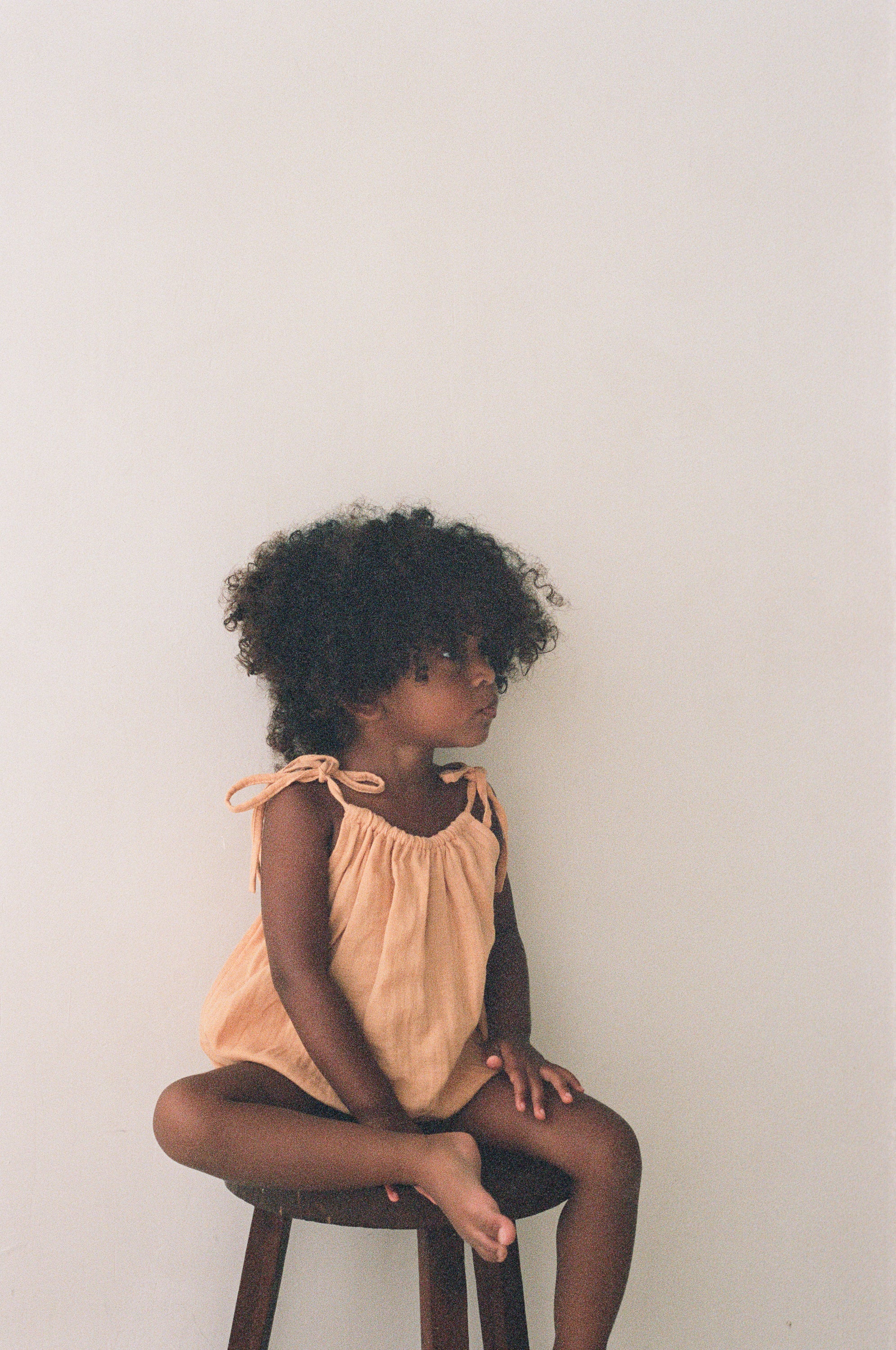 toddler girl wearing orange cotton romper by illoura the label