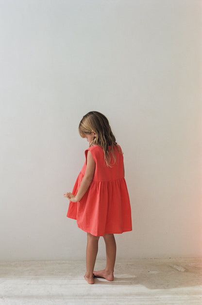 girl wearing cotton pinafore dress in red by Illoura the label