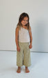 girl wearing one shoulder floral print top with gathers in 100% cotton poplin and 100% cotton handmade crochet pants